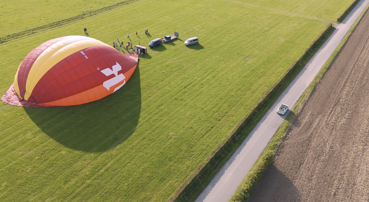 een drone shot van een luchtballon in een groen veld in Limburg